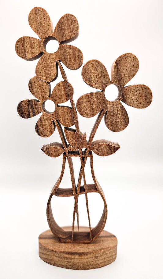 A wooden decorative sculpture of three stylized flowers in a vase, crafted from medium brown wood with visible grain, standing on a round wooden base against a white background.