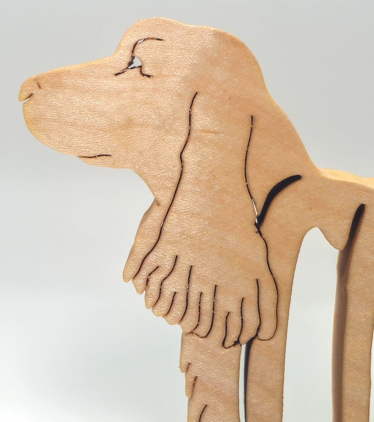 Close-up of handcrafted wooden Cocker Spaniel head and scroll-saw detail