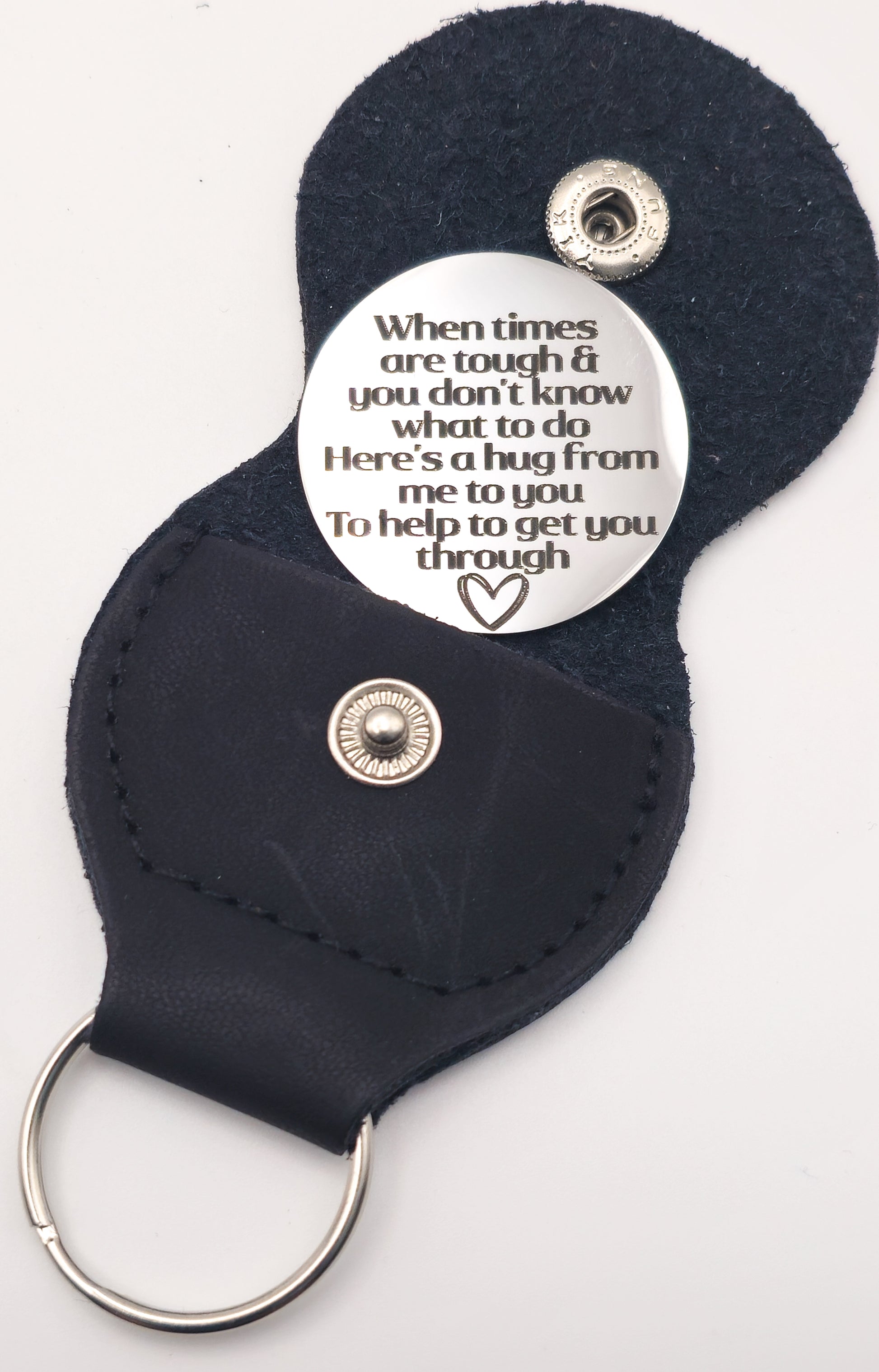 A dark navy blue leather keychain with a silver metal key ring and a round silver button featuring a printed message of support.